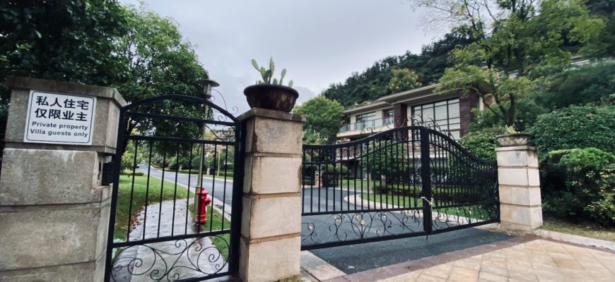 black metal fence near green trees during daytime